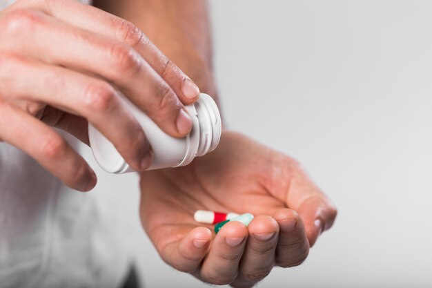 close-up hands holding medical capsules