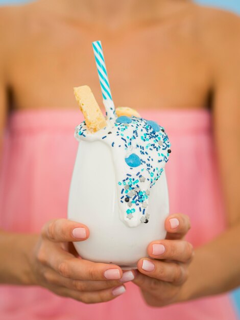 Close-up hands holding milkshake glass