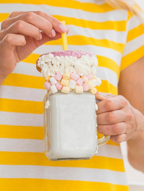 Close-up hands holding milkshake jar