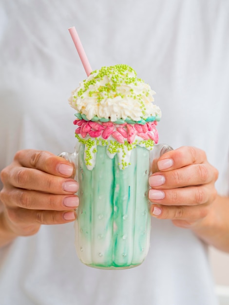 Close-up hands holding milkshake