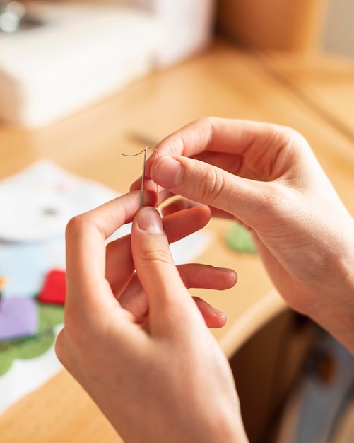 Free photo close-up hands holding needle and thread