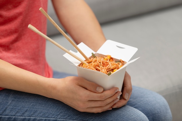 Close up hands holding noodle box