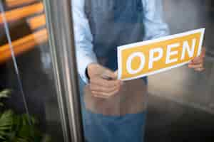 Free photo close up hands holding open sign