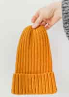 Free photo close-up hands holding orange knitted hat