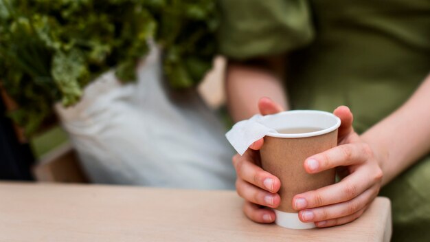Close-up hands holding organic cup of tea