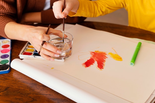 Close-up hands holding painting brushes