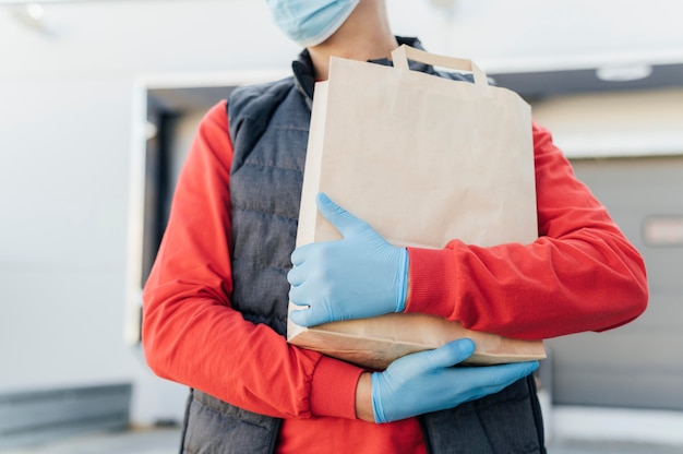 Free photo close-up hands holding paper bag