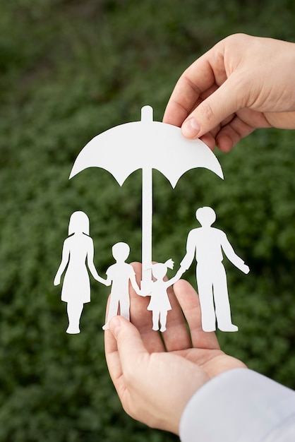 Free photo close up hands holding paper family outdoors