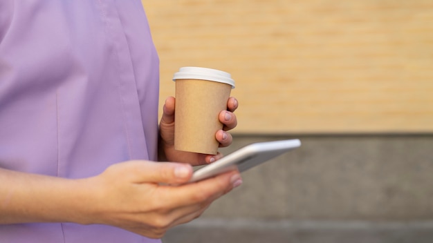 電話とコーヒーカップを持って手を閉じる