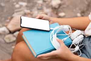 Free photo close-up hands holding phone and headphones