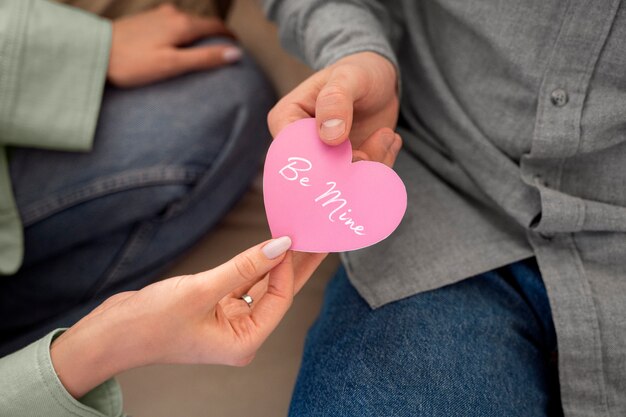 Close up hands holding pink heart