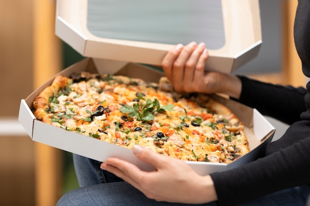 Close up hands holding pizza boxes