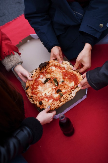 Close up hands holding pizza