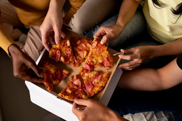 Close up hands holding pizza