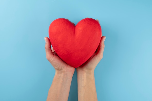 Free photo close up hands holding red heart