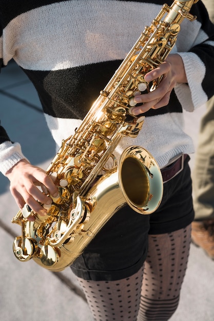 Free photo close up hands holding saxophone