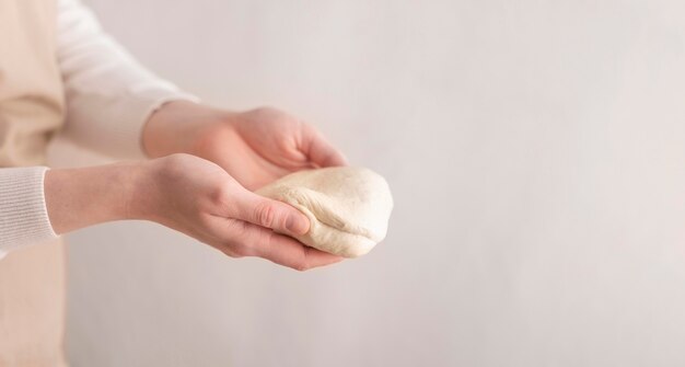 Close-up hands holding small dough