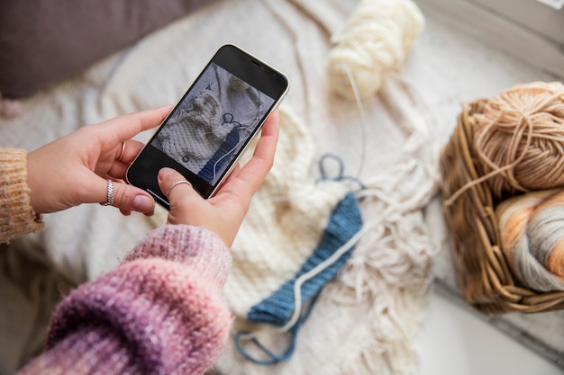 Foto gratuita chiudere le mani che tengono smartphone