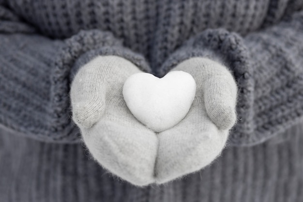 Free photo close up hands holding snow heart