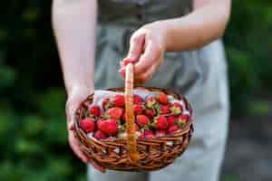 Free photo close-up hands holding strawberries basket