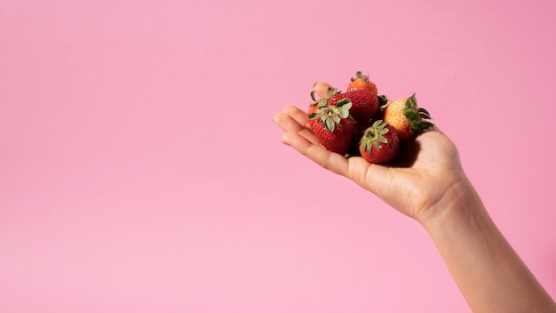 Free photo close up hands holding strawberries