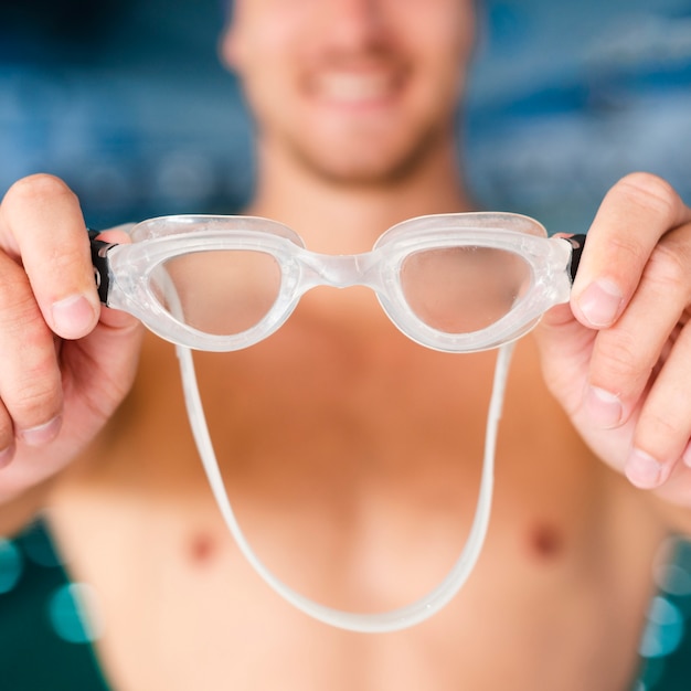 Close-up hands holding swimming goggles