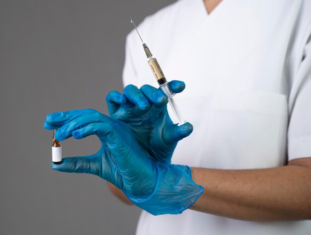 Close-up hands holding syringe and vial