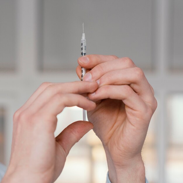 Close up hands holding syringe