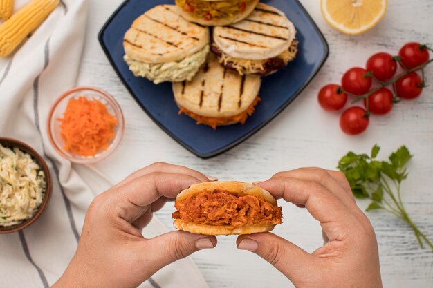 Close-up hands holding tasty arepas