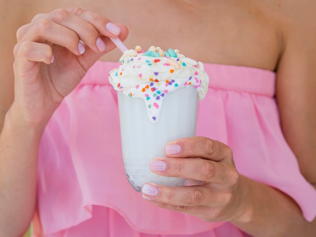 Close-up hands holding tasty milkshake