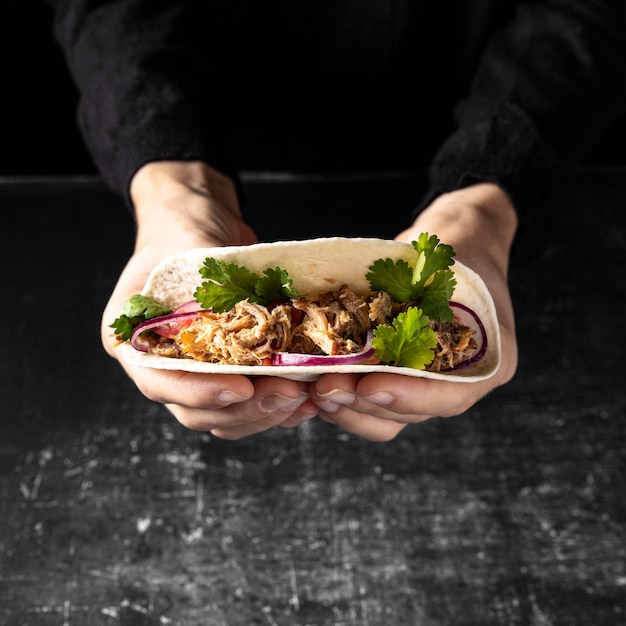 Free photo close-up hands holding tasty taco