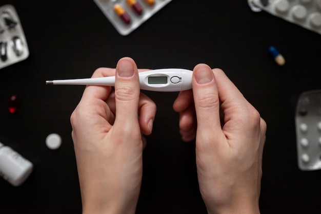 Close up hands holding thermometer