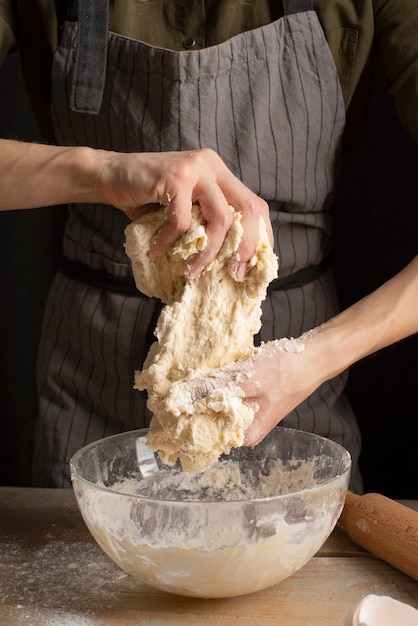 Close up hands kneading dough