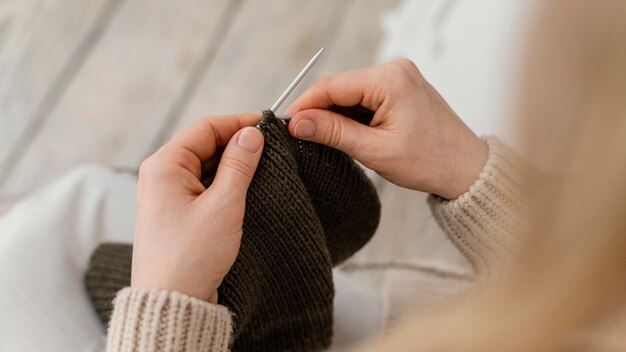 Close-up hands knitting with metallic needle