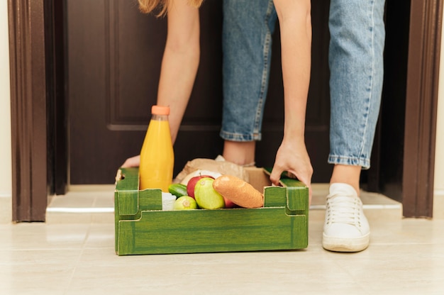 Foto gratuita mani del primo piano che sollevano la cassa del cibo