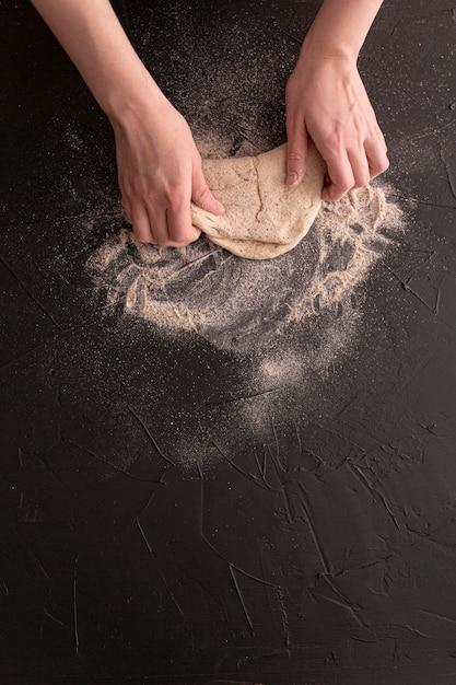 Foto gratuita mani del primo piano che producono pane