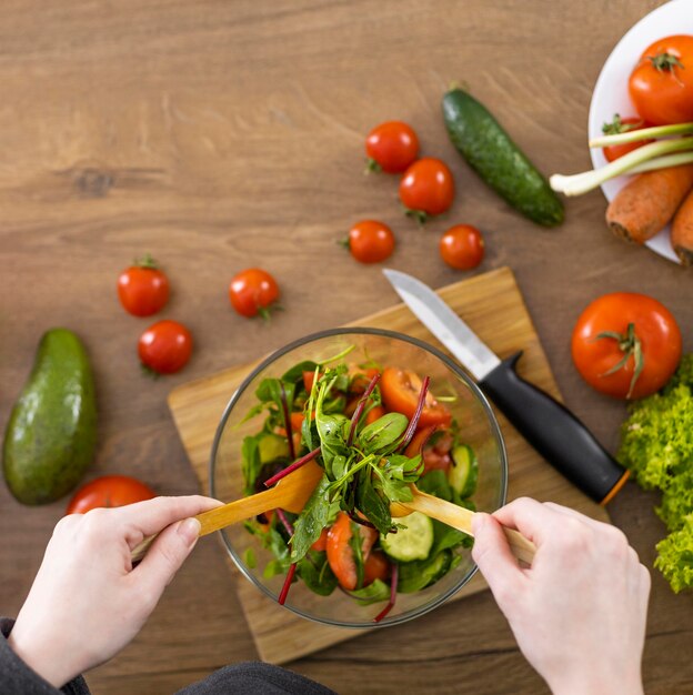 Close up hands making salad