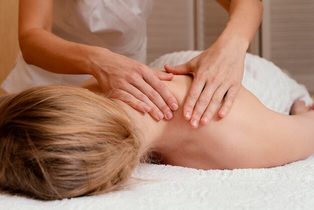 Close up hands massaging woman's back