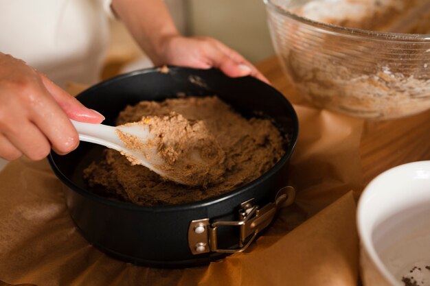 Close-up of hands mixing batter in pan