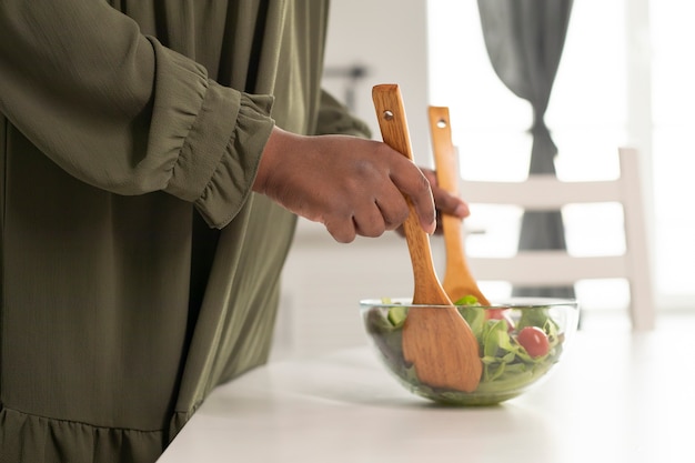 Close up hands mixing salad