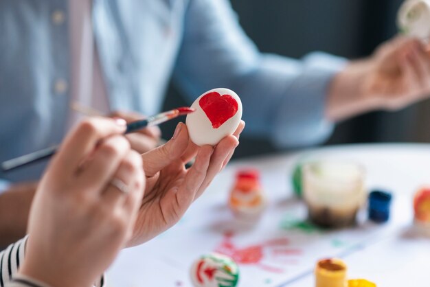 Close-up hands painting egg for easter