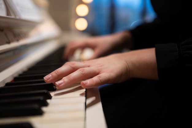 Free photo close up hands playing the piano