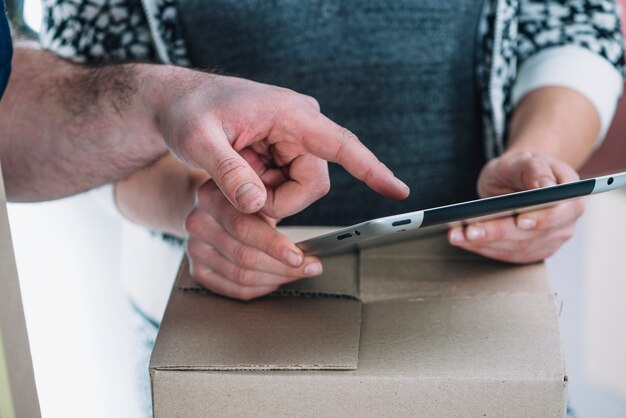 Close-up hands pointing at tablet