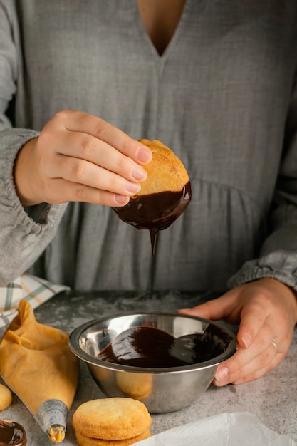 Close up hands preparing alfajores with chocolate