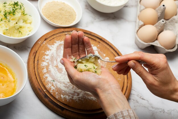 Close up hands preparing food croquettes