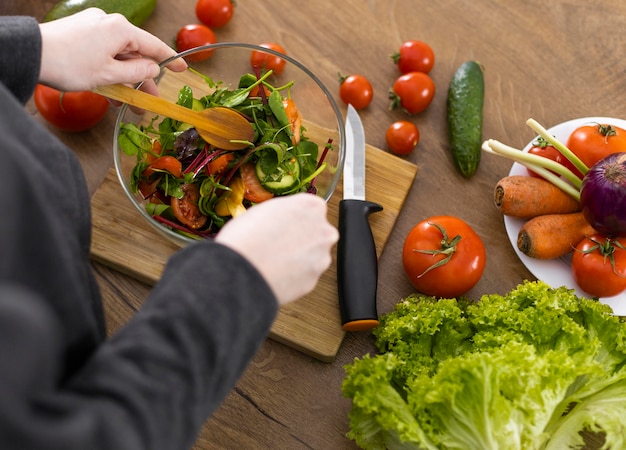 Close up hands preparing salad