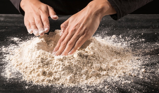 Free photo close-up hands pressing flour