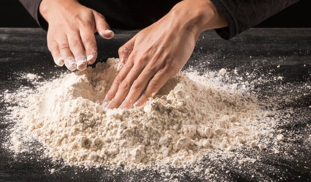 close-up hands pressing flour