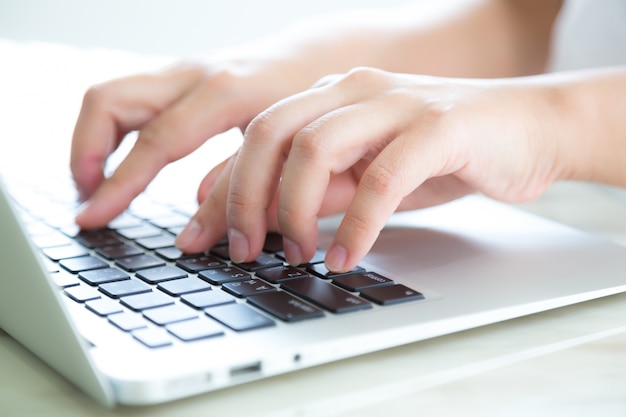 Close-up of hands pressing the keyboard