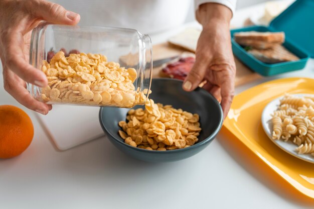 Close up hands putting cereals in bowl